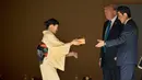 Presiden AS Donald Trump dan PM Jepang Shinzo Abe menerima kotak makanan ikan saat akan memberi makan koi di kolam Istana Akasaka, Tokyo, Senin (6/11). Beragam momen terlihat dalam kunjungan Presiden Donald Trump ke Jepang. (AP/Andrew Harnik)