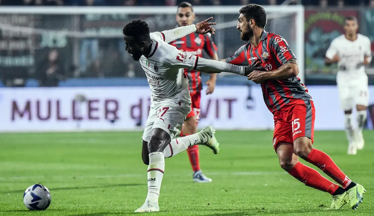 Pemain AC Milan Divock Origi (kiri) berebut bola dengan pemain Cremonese Matteo Bianchetti pada pertandingan sepak bola Serie A Liga Italia di Stadion Giovanni-Zini, Cremona, Italia, 8 November 2022. Pertandingan berakhir imbang 0-0. (Filippo MONTEFORTE/AFP)