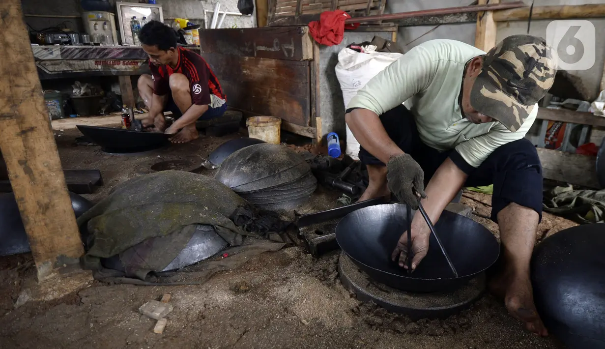 Perajin menyelesaikan pembuatan wajan yang terbuat dari pelat besi di Desa Cibadak, Tanah Sareal, Kabupaten Bogor, Jawa Barat, Rabu (5/8/2020). Pemerintah akan membantu usaha mikro, kecil, dan menengah (UMKM) dalam melewati masa pandemi COVID-19. (merdeka.com/Dwi Narwoko)