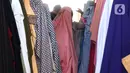 Pedagang menata bahan kain yang akan dijual di kawasan Tangerang, Banten, Sabtu (25/9/2021). Kementerian Perindustrian memberikan stimulus bagi industri tekstil dalam negeri berupa program Restrukturisasi Mesin/Peralatan Industri Penyempurnaan dan Percetakan Kain. (Liputan6.com/Angga Yuniar)