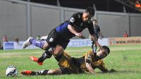 Striker Arema Cronus, Samsul Arif, ditekel pemain Mitra Kukar, Michael Orah pada laga leg pertama semifinal Piala Jenderal Sudirman. (Bola.com/Kevin Setiawan)