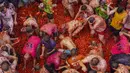 Orang-orang yang bersuka ria saling melempar tomat dalam acara tahunan "Tomatina", pesta pertarungan tomat di desa Bunol dekat Valencia, Spanyol, Rabu (31/8/2022). Seperti namanya, ratusan ton tomat disediakan untuk senjata dalam acara perang tomat. (AP Photo/Alberto Saiz)