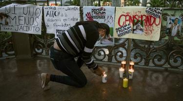 Seorang wanita menyalakan lilin selama protes menuntut keadilan atas pembunuhan jurnalis Meksiko Jacinto Romero Flores, di Orizaba, negara bagian Veracruz, Meksiko pada 19 Agustus 2021 (AFP)