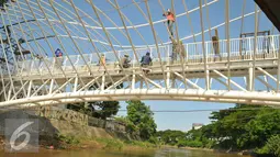 Pekerja menyelesaikan pembangunan jembatan penyebrangan orang di atas sungai Ciliwung di kawasan Manggarai, Jakarta, Senin (4/4). Rencaanya JPO tersebut siap digunakan pada 6 April mendatang. (Liputan6.com/Yoppy Renato)