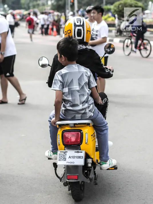 Pengendara sepeda motor listrik Migo saat melintasi CFD di kawasan Bundaran HI, Jakarta, Minggu (17/2). Petugas Dishub menghimbau penyewa untuk tidak melintasi jalan raya karena belum memenuhi uji layak operasi. (Liputan6.com/Faizal Fanani)