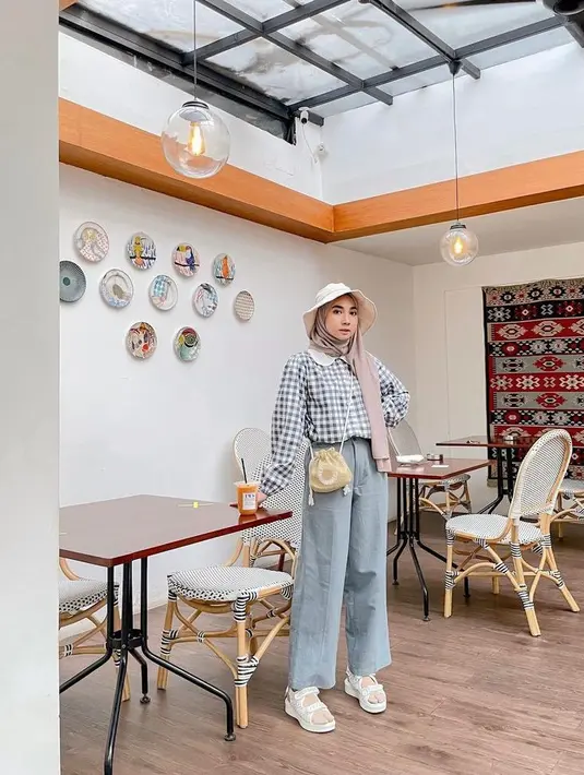 Style ala Korea identik dengan warna soft. Kombinasikan wide leg jeans warna blue jeans kamu dengan plaid blouse dengan aksen renda. Tambahkan topi sebagai pemanis. (Instagram/richaeu).