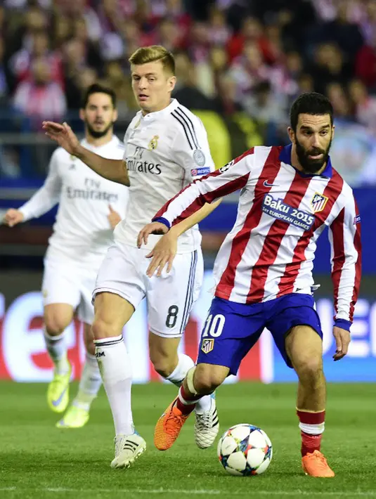 Gelandang Atletico Madrid, Arda Turan berusaha melewati pemain Real Madrid Toni Kroos di leg 8 besar Liga Champions di Vicente Calderon, Spanyol Rabu (15/4/2015). Atletico Madrid bermain imbang 0-0 dengan Real Madrid. (AFP PHOTO/GERARD JULIEN) 