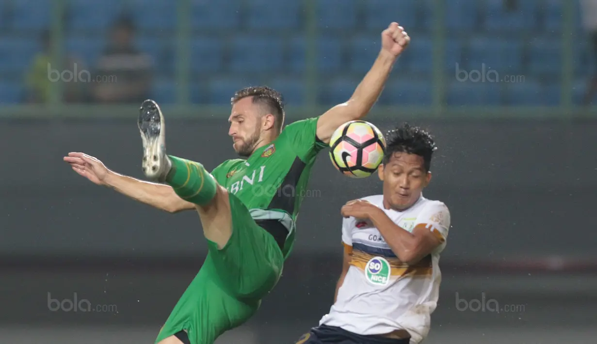 Duel pemain Bhayangkara FC, Ilija Spasojevic (kiri) dan pemain Persela Lamongan, Zainal Haq pada lanjutan Liga 1 2017 di Stadion Patriot, Bekasi, (27/10/2017). Bhayangkara menang 3-1. (Bola.com/Nicklas Hanoatubun)