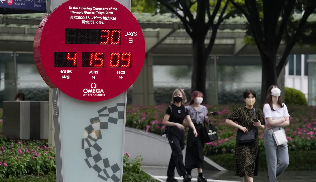 Orang-orang berjalan dekat jam hitung mundur yang menunjukkan 30 hari menuju pembukaan Olimpiade Tokyo 2020 di Tokyo, Rabu (23/6/2021). Olimpiade Tokyo dimulai pada 23 Juli dan penyelenggara mengizinkan penonton lokal menghadiri venue pertandingan dengan kapasitas 50 persen. (AP Photo/Kiichiro Sato)
