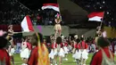 Penari mengibarkan bendera Merah-Putih saat acara pembukaan Torabika Soccer Championship 2016 di Stadion Mandala, Jayapura, Papua, Jumat (29/4/2016). (Bola.com/Nicklas Hanoatubun)