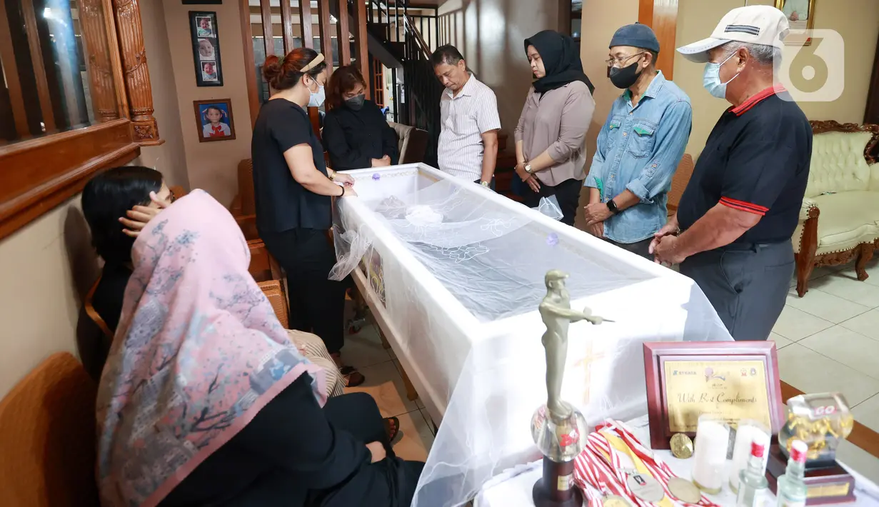 Pelayat berdiri di samping peti jenazah mantan pelatih Tim Nasional Indonesia, Benny Dollo saat disemayamkan di rumah duka kawasan Pamulang, Tangerang Selatan, Kamis (2/2/2023). Bendol-sapaan akrabnya-meninggal di usia 72 tahun. (Bola.com/Muhammad Iqbal Ichsan)