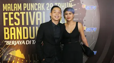 Pasangan komika Ernest Prakasa dan istrinya, Meira Anastasia, ketika berpose di red carpet Festival Film Bandung (FFB) 2016 di kawasan Monumen Perjuangan Rakyat Jawa Barat, Jawa Barat, Sabtu (24/9). (Liputan6.com/Herman Zakharia)