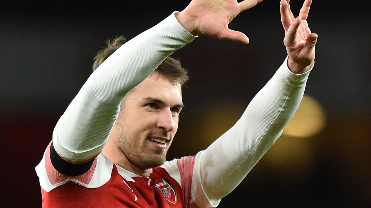 Gelandang Arsenal, Aaron Ramsey, merayakan gol yang dicetaknya ke gawang Fulham pada laga Premier League di Stadion Emirates, London, Selasa (1/1). Arsenal menang 5-1 atas Fulham. (AFP/Glyn Kirk)