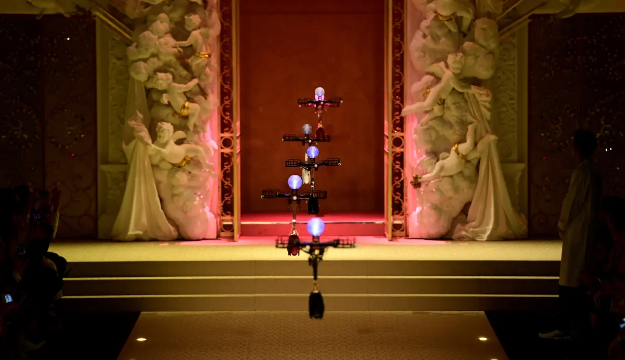 Deretan pesawat tanpa awak (drone) membawa koleksi tas tangan Dolce & Gabbana pada Milan Fashion Week 2018, Minggu (25/). Drone ini keluar dari belakang panggung, lalu terbang sambil membawa koleksi tas yang harganya terbilang selangit (Miguel MEDINA/AFP)