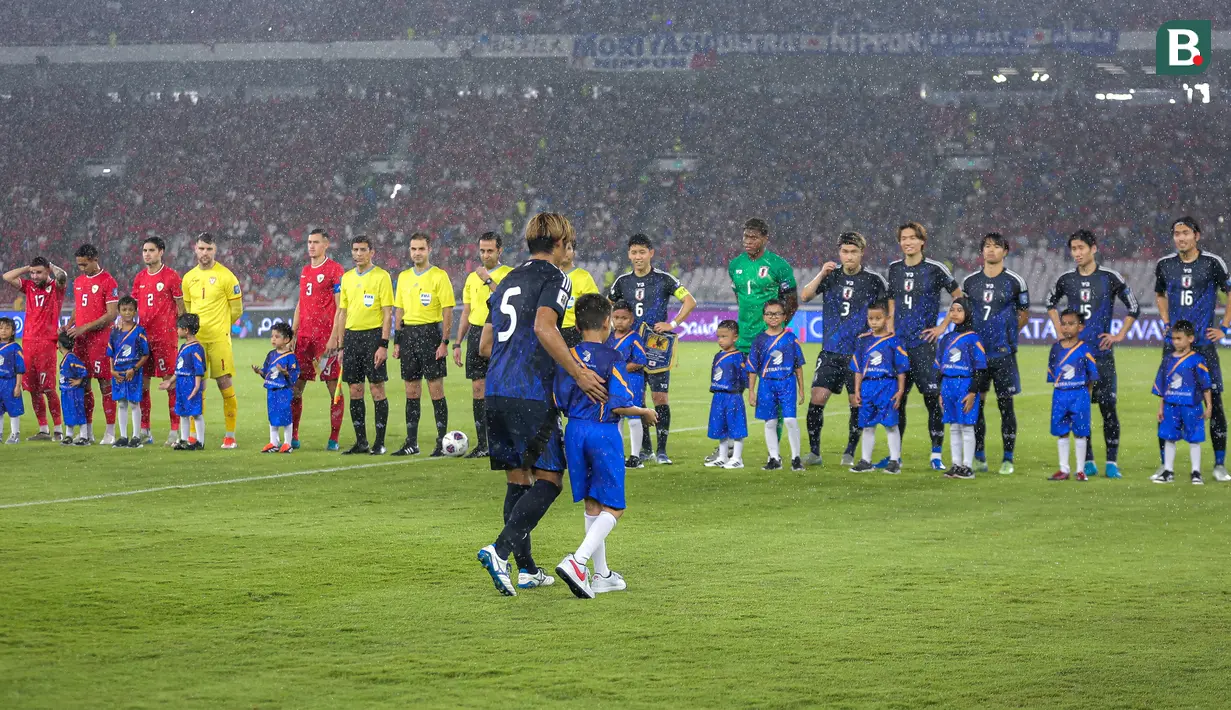 <p>Pemain Jepang, Hidemasa Morita dengan sabar menuntun anak kecil yang bertugas sebagai player escort dalam pertandingan lanjutan putaran ketiga Grup C Kualifikasi Piala Dunia 2026 melawan Timnas Indonesia di Stadion Utama Gelora Bung Karno (SUGBK), Senayan, Jakarta, Jumat (15/11/2024). (Bola.com/Bagaskara Lazuardi)</p>