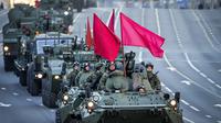 Kendaraan lapis baja Rusia yang dihiasi bendera merah melintasi sepanjang jalan Tverskaya menuju Lapangan Merah untuk menghadiri latihan parade militer Hari Kemenangan di Moskow, Rusia, Rabu (4/5/2022). Pawai akan berlangsung pada Mei 9 untuk merayakan 77 tahun kemenangan dalam Perang Dunia II. (AP Photo/Alexander Zemlanichenko)