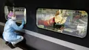 Petugas medis melihat pasien virus corona COVID-19 dalam kereta kecepatan tinggi TGV dari peron Stasiun Gare d'Austerlitz di Paris, Prancis, Rabu (1/4/2020). Prancis mengerahkan kereta kecepatan tinggi untuk mengevakuasi pasien COVID-19 dari Paris ke wilayah Brittany. (Thomas SAMSON/AFP/POOL)