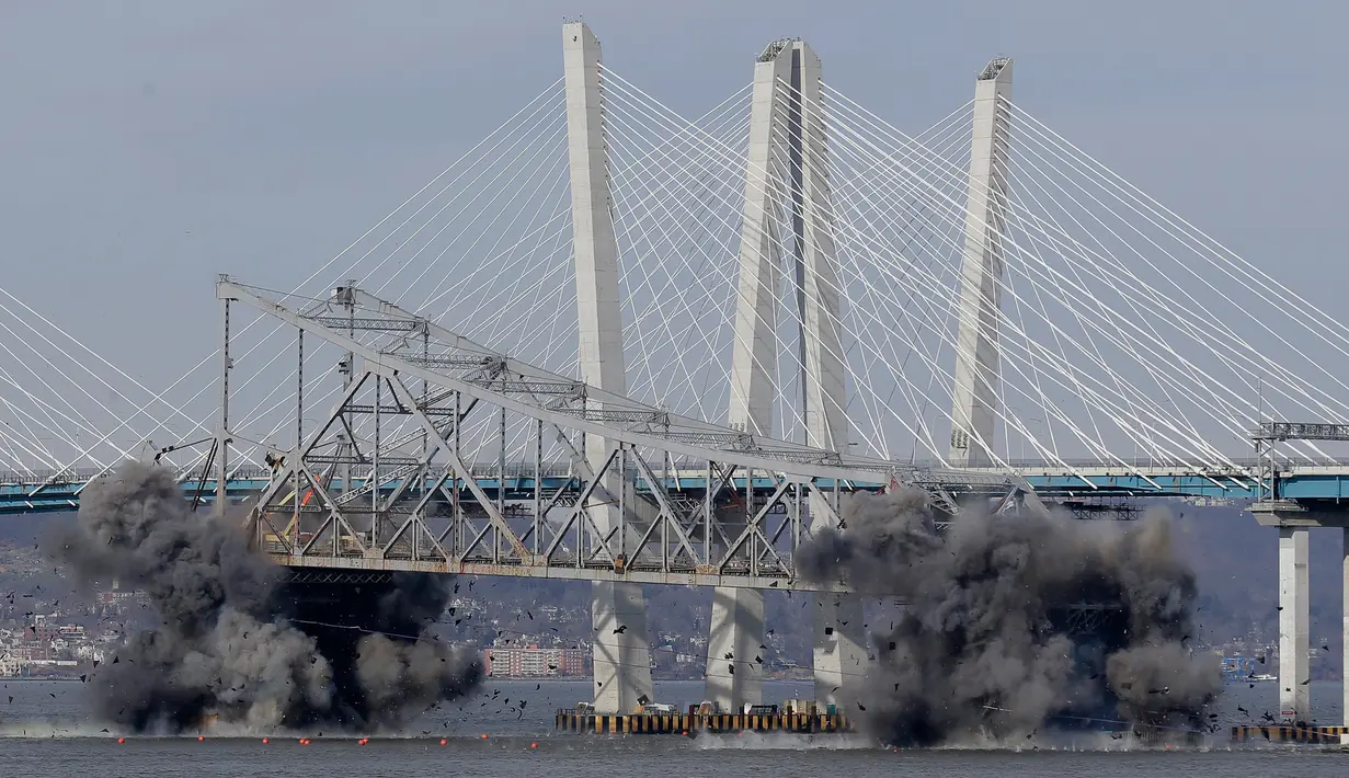 Ledakan dahsyat menghancurkan bagian Jembatan Tappan Zee di Tarrytown, New York, AS, Selasa (15/1). Ratusan orang berkumpul di tepi sungai untuk menyaksikan penghancuran Jembatan Tappan Zee. (AP Photo/Seth Wenig)