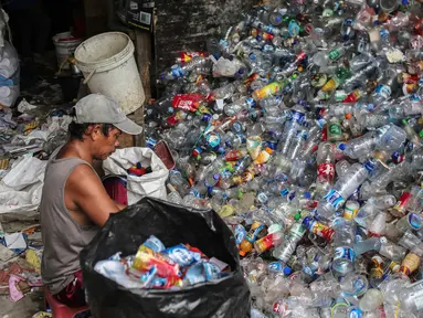Warga memilah sampah plastik di permukiman liar di kawasan Bypass, Pramuka, Jakarta Timur, Rabu (21/2). Lahan seluas 9.820 meter persegi milik Pemprov DKI tersebut rencananya akan dibangun kantor pemadam kebakaran. (Liputan6.com/Faizal Fanani)