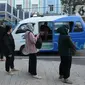 Para calon penumpang antre menunggu giliran untuk naik transportasi layanan angkutan umum JakLingko di Stasiun Klender Baru, Pondok Kopi, Jakarta, Senin (19/2/2024). (merdeka.com/Imam Buhori)