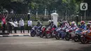 Presiden Joko Widodo (Jokowi) melepas iring-iringan pembalap MotoGP di depan Istana Merdeka, Jakarta Pusat, Rabu (16/3/2022). Parade MotoGP tersebut merupakan rangkaian kegiatan sebelum para pembalap berlaga di MotoGP Mandalika yang berlangsung pekan ini. (Liputan6.com/Faizal Fanani)