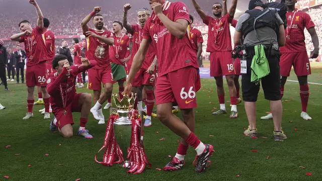 Trent Alexander-Arnold dengan trofi Premier League 2024/2025 usai laga Liverpool vs Crystal Palace, Minggu (25/05/2025). (AP/Jon Super)