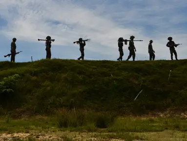 Sejumlah prajurit TNI dari batalyon infantri Raider 112 berjalan membawa berbagai senjata selama latihan menembak di Mata Ie, Aceh Besar, Aceh, Selasa (11/6/2019). Latihan menembak ini untuk memelihara dan meningkatkan kemampuan prajurit Raider.  (AFP Photo/Chaideer Mahyuddin)