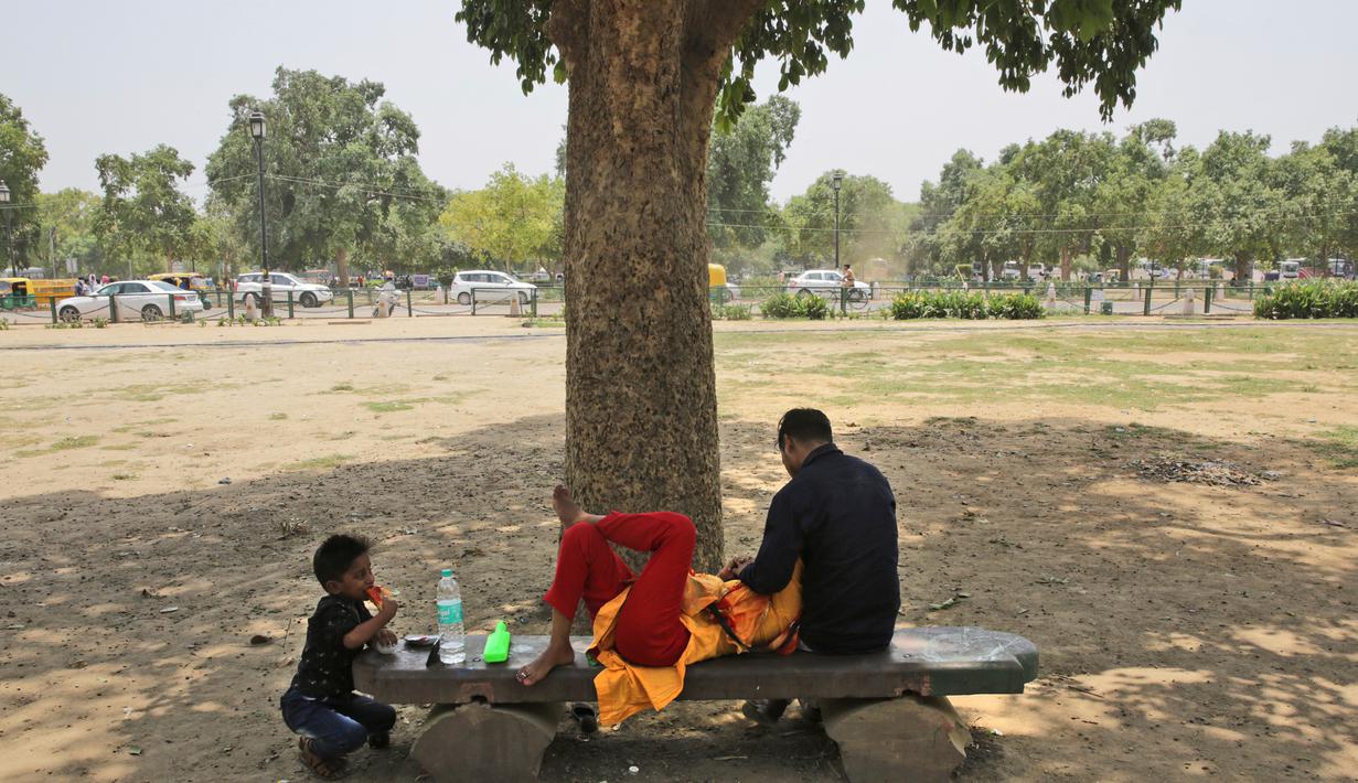 Keluarga beristirahat di bawah pohon selama musim panas di New Delhi, India (10/6/2019). Kondisi gelombang panas yang parah menyapu bagian utara dan barat India dengan suhu maksimum melonjak hingga 48 derajat Celcius ( 118 F) di beberapa bagian Rajasthan. (AP Photo/Manish Swarup)