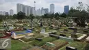 Warga melewati area makam TPU Karet Bivak, Jakarta (2/2). Dinas Pertamanan dan Pemakaman DKI telah menerapkan sistem online dalam pelayanan pemakaman di Ibukota dengan alamat situs pertamananpemakaman.jakarta.go.id. (Liputan6.com/Gempur M Surya)