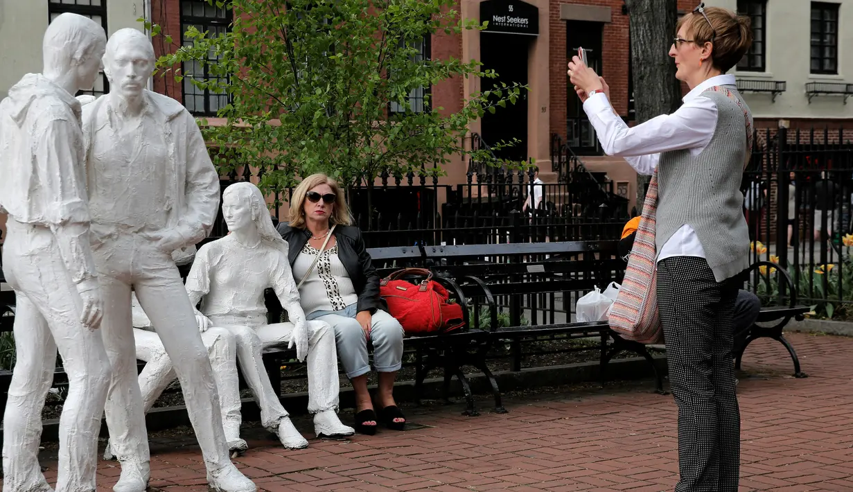  Seorang wanita memotret patung yang disebut 'Gay Liberation' di Christopher Park, Greenwich Village New York City, AS, (9/5). Patung ini dibuat pada tahun 1979 oleh pematung George Segal. (REUTERS / Brendan McDermid)