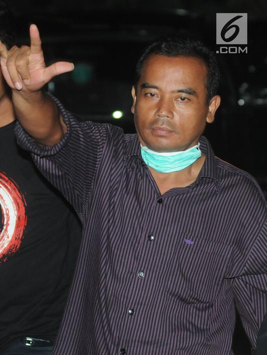 Bupati Purbalingga Tasdi mengacungkan salam saat tiba di Gedung KPK, Jakarta, Selasa (5/6). Tasdi terjaring Operasi Tangkap Tangan KPK terkait kasus dugaan suap proyek infrastruktur di Kabupaten Purbalingga, Jawa Tengah. (Merdeka.com/Dwi Narwoko)