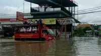 Petugas BNPD dan Pemadam Kebakaran Kota Tangerang bantu para siswa menyeberangi banjir (Liputan6.com/Pramita Tristiawati)
