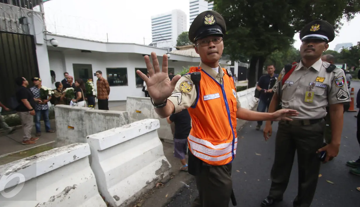Petugas keamanan melarang wartawan untuk mengambil gambar di depan Kantor Kedubes AS, Jakarta, Selasa (14/6). Ketatnya penjagaan di sekitar Kantor Kedubes menyebabkan sejumlah wartawan mengalami kesulitan untuk meliput. (Liputan6.com/Immanuel Antonius)