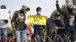 Massa aksi yang tergabung dari elemen mahasiswa, buruh, dan pelajar membawa spanduk dalam unjuk rasa di depan Gedung DPR RI, Jakarta, Senin (30/9/2019). Aksi unjuk rasa tersebut menyikapi penolakan terhadap UU KPK dan sejumlah RUU yang dinilai bermasalah. (Liputan6.com/Immanuel Antonius)