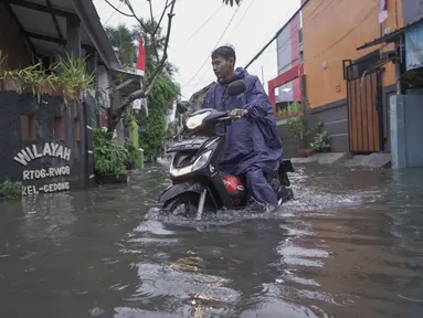 Warga melintasi genangan air di kawasan RT 10 RW 08, Kelurahan Gedong, Kecamatan Pasar Rebo, Jakarta Timur, Senin (4/8/2025). (merdeka.com/Arie Basuki)