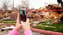 Warga mengabadikan gambar reruntuhan rumah yang disapu oleh angin tornado di Texas, Amerika Serikat, (28/12). Sedikitnya 11 orang tewas di daerah Dallas akibat tornado ini. (REUTERS/Todd Yates)