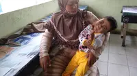 Yeni, warga Ogan Ilir Sumsel, menatap dalam wajah anaknya, Putri Ayu Anisa (4), yang mengidap penyakit komplikasi sejak usia 4 bulan (Liputan6.com / Nefri Inge)