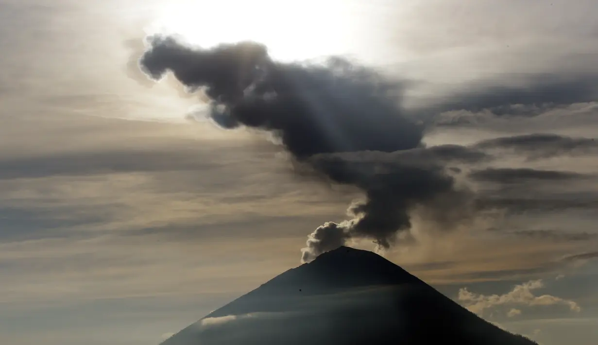 <p>Embusan asap keluar dari kawah Gunung Agung ketika matahari terbit (sunrise) yang terlihat dari Kintamani, Bali, Rabu (13/12). BNPB menegaskan bahwa kondisi Pulau Bali aman bagi wisatawan meski Gunung Agung berstatus siaga. (AP Photo/Firdia Lisnawati)</p>