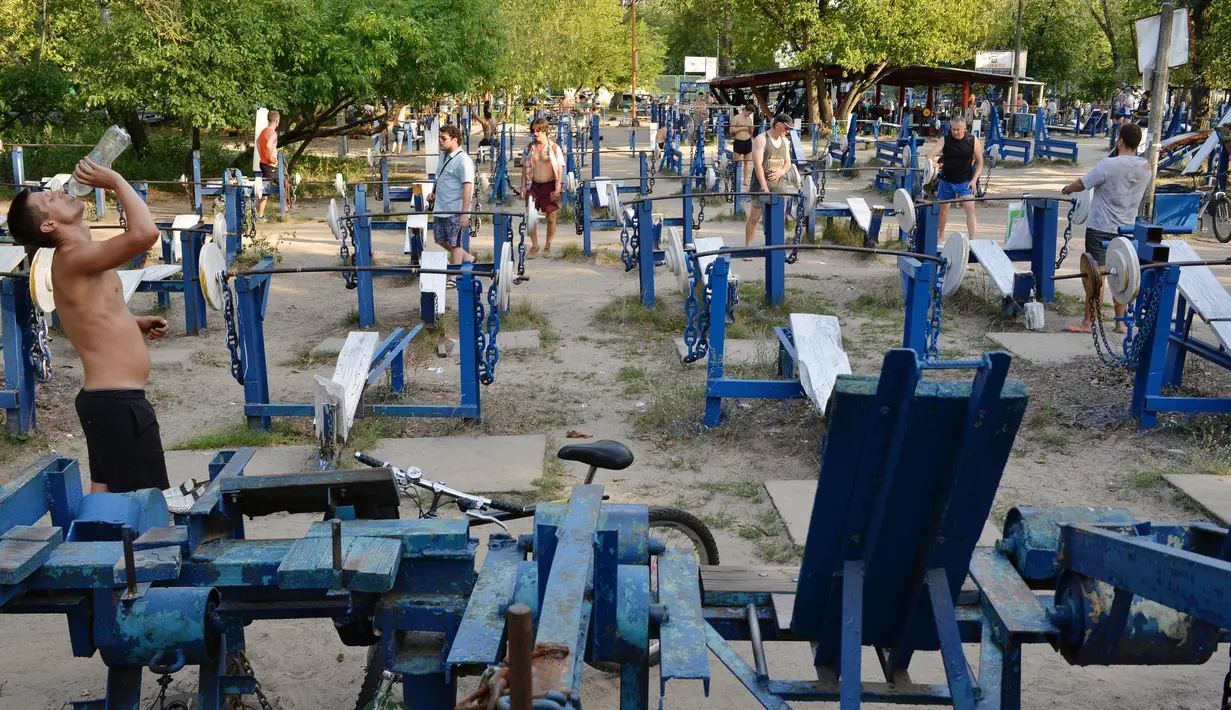 Sejumlah orang melakukan latihan beban di sebuah gym outdoor di Ibu Kota Ukraina, Kiev, 18 Agustus 2017. Warga yang sudah berpengalaman bisa menyesuaikan alat olahraga di sana agar sesuai dengan jenis latihan yang dilakukan. (GENYA SAVILOV/AFP)