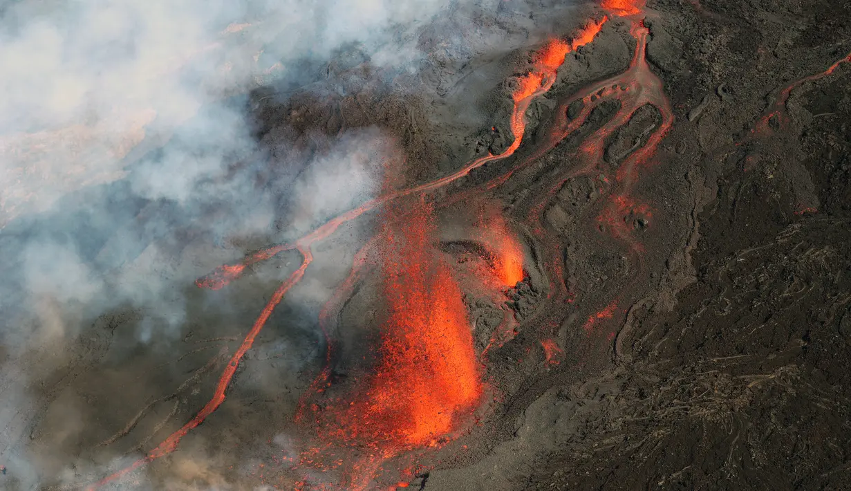 Foto udara pada 22 Desember 2021 menunjukkan gunung berapi Piton de la Fournaise yang meletus di pulau Reunion, Samudra Hindia Prancis. Letusan terjadi di daerah yang sama sekali tidak berpenghuni. (Richard BOUHET/AFP)