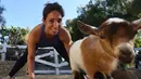 Ekspresi seorang peserta saat mengikuti kelas "Goat Yoga" atau Yoga Kambing di Thousand Oaks, California (4/6). Dalam kelas yoga kambing ini, beberapa ekor kambing akan melompat-lompat di kelas menghibur para peserta. (AFP Photo/Mark Ralston)