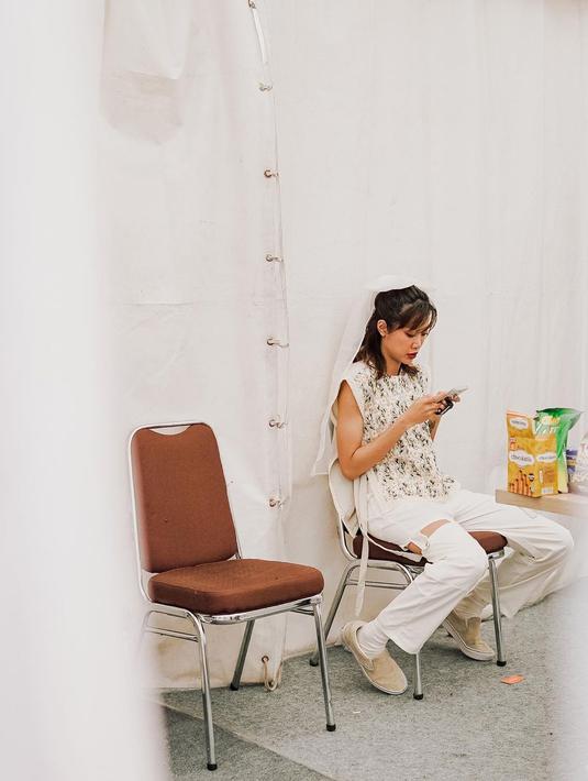 Sambil menunggu waktunya manggung, Widi Vierratale, memilih untuk menghabiskan waktu dengan gadgetnya. (Foto: Instagram/@widikidiwdkdw)