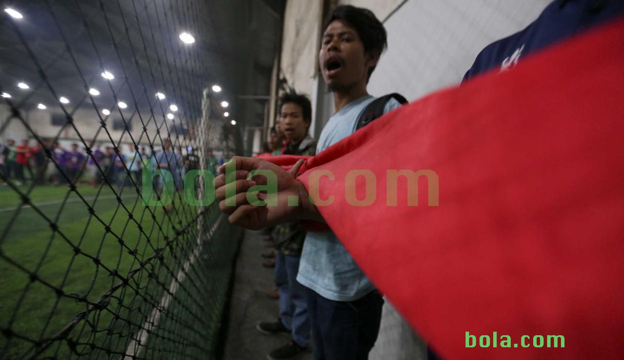 Suporter bernyanyi sambil menggulug bendera Merah-Putih raksasa di Tangerang, Sabtu (31/10/2015). Selain ingin mencatat rekor dunia, tema dasar adalah "One Soul, One Nation Untuk Sepakbola Indonesia".  (Bola.com / Nicklas Hanoatubun).