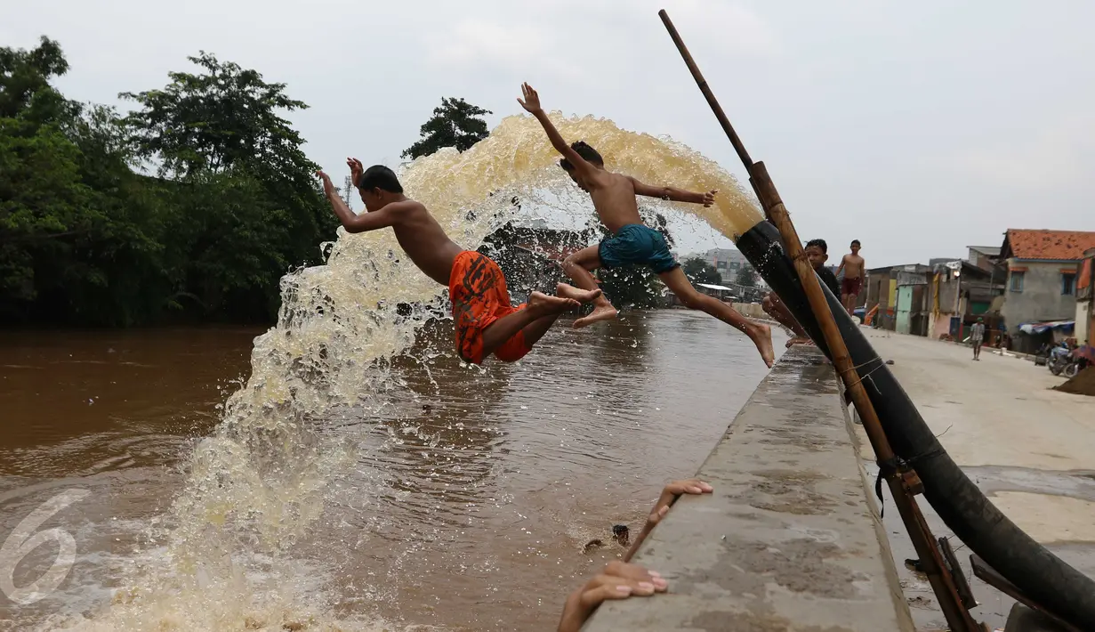 Sejumlah anak bermain di bantaran kali Ciliwung, Kampung Pulo, Jakarta Timur, Sabtu (12/3). Warga memanfaatkan lahan di aliran sungai untuk tempat bermain karena minimnya lahan kosong di sekitar wilayah itu.(Liputan6.com/Gempur M Surya)