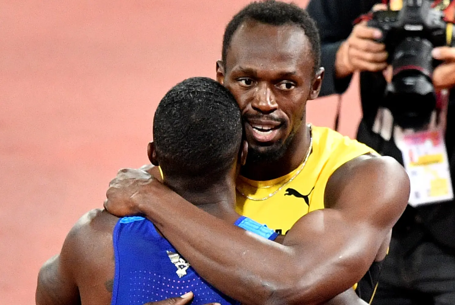 Pelari Jamaika, Usain Bolt, memeluk rivalnya, Justin Gatlin, setelah final lari nomor 100 meter Kejuaraan Dunia Atletik di London, Sabtu (5/8/2017) malam waktu setempat. (AP/Martin Meissner)