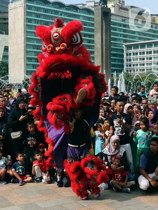 Warga menyaksikan pertunjukkan barongsai saat ajang car free day (CFD) di kawasan Bundaran HI Jakarta, Minggu (26/1/2020). Barongsai tersebut sengaja dihadirkan dalam rangka perayaan Imlek 2020 untuk menghibur para warga yang tengah mengikuti CFD. (Liputan6.com/Johan Tallo)
