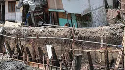 Sejumlah rumah hampir ambruk akibat amblesnya tanah di bantaran Anak Kali Ciliwung di Jalan Lodan Raya, Pademangan, Jakarta, Senin (19/11). Petugas mengungsikan warga ke tempat pengungsian sementara. (Liputan6.com/Faizal Fanani)
