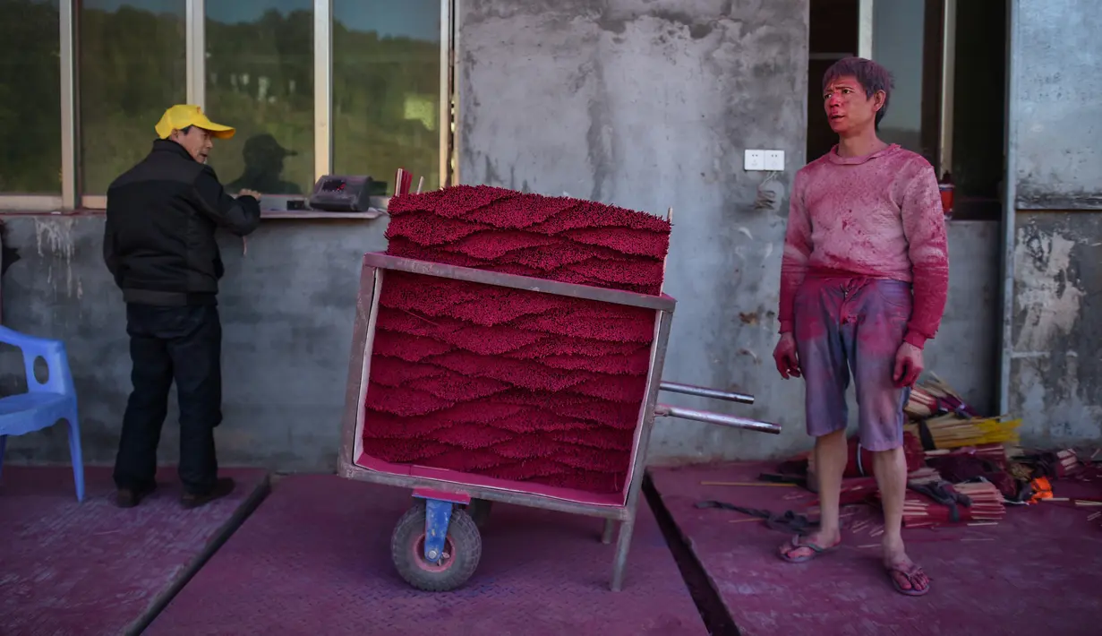 Gambar pada 11 Desember 2019, pekerja  menunggu untuk menimbang dupa yang dia produksi di Pabrik Dupa Fujian Xingquan, Provinsi Fujian, China. Mendekati liburan Tahun Baru Imlek, ini adalah waktu yang penting tahun bagi penduduk desa ini yang memasok banyak dupa dunia. (HECTOR RETAMAL/AFP)