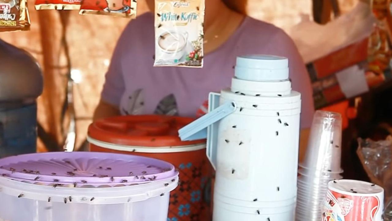 Barang dagangan yang ada di atas meja dikerubuti oleh lalat. Mulai dari gorengan yang baru saja jadi, hingga sisa minuman milik para pemulung.
