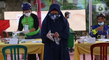 Pemiilih mengenakan sarung tangan plastik saat menggunakan hak suaranya dalam Pilkada Tangerang Selatan di TPS 23 Pondok Jagung Timur, Rabu (9/12/2020). Menggunakan masker hingga memakai sarung tangan plastik menjadi hal wajib saat melakukan pencoblosan di Pilkada 2020. (Liputan6.com/Angga Yuniar)